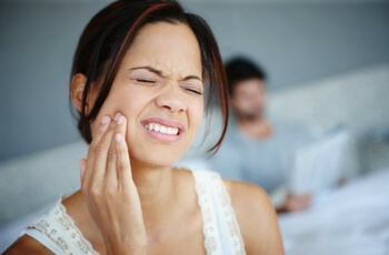 Woman grabbing jaw.