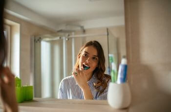 Woman brushing teeth.