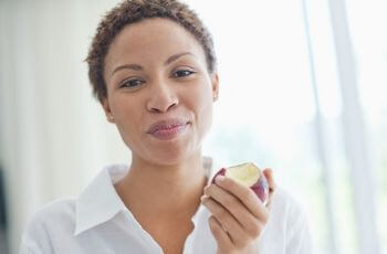 Woman chewing apple.
